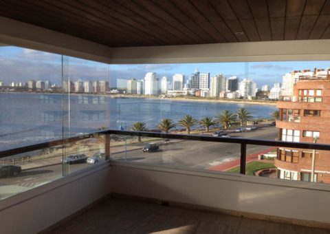 Cerramiento de balcón realizado en cristal incoloro de 10 mm, con sistema corredizo sobre guía de aluminio, zona Península Punta del Este